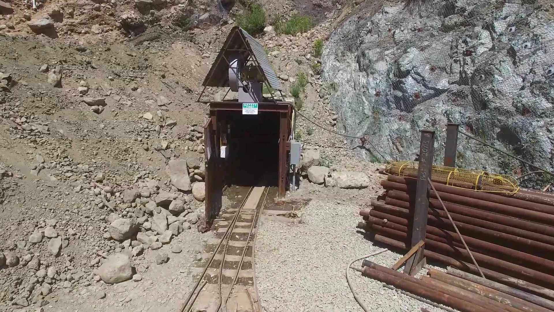 A timber-framed mine portal with rail tracks