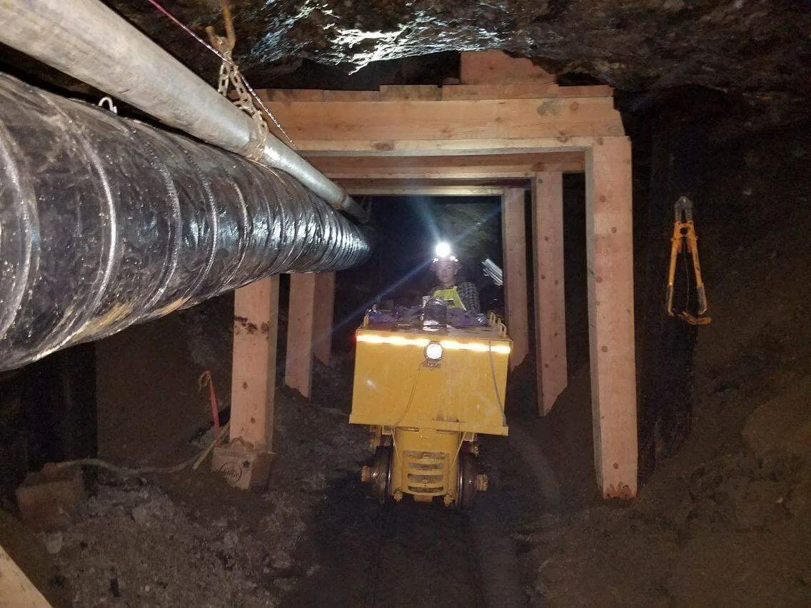 Underground equipment beneath a timbered opening.